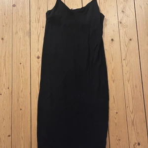 Svart ärmlös klänning - Elegant svart ärmlös klänning i lång modell. Perfekt för en stilren look. Klänningen har en enkel design som gör den lätt att matcha med olika accessoarer. Den är från  & other  stories och har inte används nästa något alls