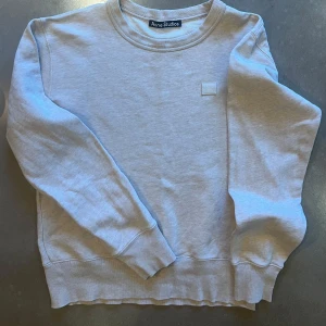 Ljus beige melerad sweatshirt från Acne Studios - Säljer en stilren ljusbeige melerad sweatshirt från Acne Studios i 100% bomull. Tröjan har en klassisk rund hals och långa ärmar med ribbade muddar. Perfekt för en avslappnad look. 🩶       Se bild 4, litet hål vid ärmslut.
