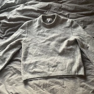 Grå stickad från other stories  - Mysig stickad tröja från other stories. Endast använd 1 gång, köpt för 690kr o säljs ej längre!