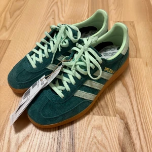 Adidas Handball Spezial i grönt - Adidas Handball Spezial sneakers i grön färg. Aldrig använda därav prislapp kvar. Köpta på en skobutik i London som heter Schuh. Nypris 1349kr säljer för 900kr🫶🏼