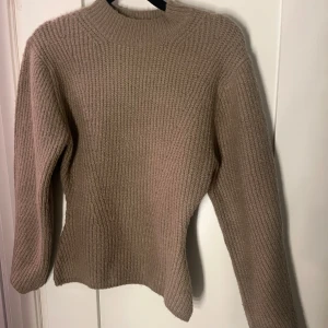 Beige stickad tröja från Nelly - Säljer en mysig beige stickad tröja från Nelly. Perfekt för kyliga dagar med sin varma och bekväma design. Tröjan har långa ärmar och en klassisk rund halsringning. Passar utmärkt till både jeans och kjol. 🧶✨