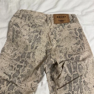 Ormmönstrade byxor från Rocky - Coola ormmönstrade byxor från Rocky. Säljer pga att de tyvärr har blivit för små. 
