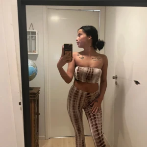 Brun och vit tubtopp - Snygg brun och vit SET med ett rutigt mönster. Perfekt för en trendig look. Matchande  med byxorna  i samma stil för en komplett outfit.