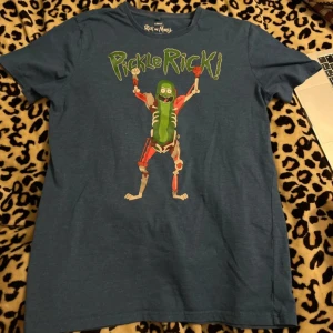 Blå Rick and Morty t-shirt med Pickle Rick - Säljer en blå t-shirt med ett coolt Pickle Rick-tryck från Rick and Morty. lite använt skick men fortfarande bra, storlek L