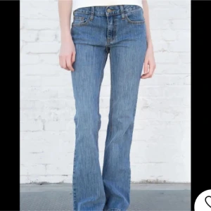 Blå bootcut jeans från brandy  - Snygga blå bootcut jeans med låg midja. Perfekta för en avslappnad stil. Klassisk femficksdesign och knappgylf.