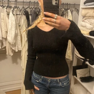 Svart långärmad tröja stickad - Säljer en stilren svart långärmad tröja med tight passform. Perfekt för en enkel och elegant look. Tröjan är mångsidig och kan matchas med olika outfits.