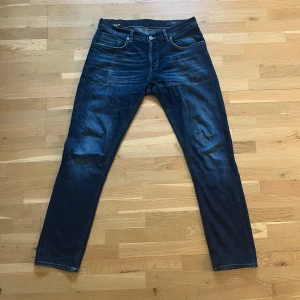 Dondup George - Säljer ett par mörkblåa dondup jeans med något bredare passform (mellan slim och straight). Jeansen är uppsydda för att passa mig som är 183 cm. Jeansen passar perfekt till någon som är mellan 180 och 185cm.