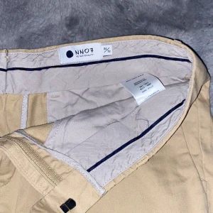 Beige byxor från NN07 - Snygga beige byxor från NN07 i en klassisk stil. Byxorna har en rak passform och är tillverkade i ett bekvämt material. Perfekta för en stilren look.