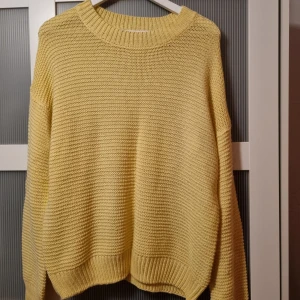 Gul stickad tröja - Säljer en mysig gul stickad tröja med rund hals och långa ärmar. Perfekt för kyliga dagar och ger en härlig färgklick till garderoben. Passar bra till jeans eller kjol för en avslappnad look.
