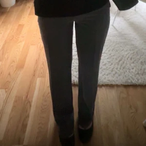 Grå kostymbyxor - Snygga grå kostymbyxor med medelhög midja och en klassisk rak passform. Perfekta för en stilren look. Byxorna har diskreta fickor och en smidig dragkedja framtill. Innerbenslängd 81cm. Byxorna är nya, använda max 2 gånger. (Köpta på bikbok för 599kr, helt slutsålda på deras hemsida)