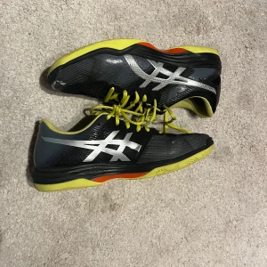 Svarta och gula träningsskor från Asics - Säljer ett par svarta träningsskor från Asics. Sitter skönt och använda relativt lite. Storlek: Eu45