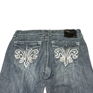 Xtreme couture Afflication Jeans - Midjemått rakt över: 42,5cm Ytterbenet: 101cm innerbenet: 77,5cm. Kontakta vid intresse och frågor!