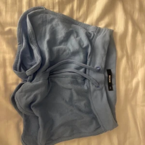 Blå shorts från bikbok - Säljer ett par bekväma blå shorts från bikbok. De har en elastisk midja med snörning för justerbar passform. Perfekta för en avslappnad dag eller träning.