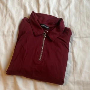 Vinröd tröja med dragkedja - Snygg vinröd tröja från Zara med dragkedja framtill och klassisk krage. Perfekt för en stilren look. Använd två gånger 