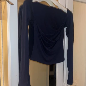 Mörkblå topp från Gina Tricot - Snygg mörkblå soft touch topp från Gina Tricot med långa ärmar och draperad detalj framtill. Skönt material och använd ett fåtal gånger