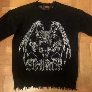Svart tröja med tryck från Seams - Häftig och unik tröja från Seams. Tröjan har en rå kant vid halsen och ärmsluten, vilket ger en edgy look. Tröjan är helt oanvänd så skicket är 10/10. Nypris på den är 1100 så 399 är ett kap. Den passar S-M