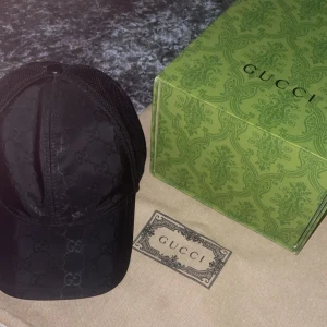 Svart keps från Gucci - Snygg svart keps från Gucci med det ikoniska GG-mönstret. Kepsen har en justerbar baksida i mesh för bättre ventilation och passform. Perfekt för en stilren look.