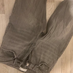 Grå jeansbyxor - Snygga grå jeansbyxor med klassisk femficksdesign och dragkedja. Perfekta för en avslappnad stil.