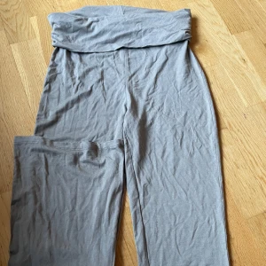 Grå lågmidjade mjukisbyxor - Säljer ett par bekväma grå mjukisbyxor med loose passform. Perfekta för en avslappnad dag hemma eller en lugn promenad. Byxorna har en bred midja för extra komfort. Använd 1 gång, skrynklig går att stryka