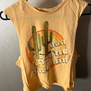 Gul ärmlös topp från Bik Bok - Säljer en gul ärmlös topp från Bik Bok med tryck. Endast använd 1 gång! Storlek xs. 