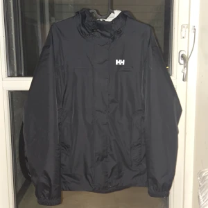 Helly Hansen Seven J Regnkläder, Herr, Svart - Jackan har en hellång dragkedja med skyddsflärp, justerbar och hopfällbar huva, justerbar nederkant och ärmslut samt två fickor med dragkedja. Byxorna har resår i midjan och har justerbar midja och benslut. Nätfodret i byxorna förbättrar ventilationen ytterligare så att byxorna alltid är bekväma att ha på sig.  Regnstället är tillverkat av mikroliknande material som ger stor rörelsefrihet samtidigt som det är snabbtorkande. Alla sömmar är tejpade för optimal vattentäthet. Nypris 2698 | Mitt 700