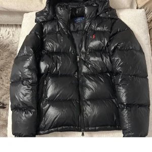 Svart dunjacka från Ralph Lauren - Snygg svart dunjacka från Ralph Lauren. Köpt på Plick. Använt den fåtal gånger, den jag köpte av hade endast provat! Köpt för 3500. Skriv för mer bilder