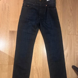 Mörkblå jeans från Boss - Snygga mörkblå jeans från Boss i regular fit. Klassisk design med fem fickor. Perfekta för en stilren look. HELT NYA. Modellen 'Maine BC-L-P'.  W29 L32 NYPRIS 1099