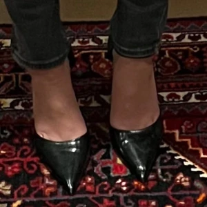 Svarta pumps med klack - Eleganta svarta pumps i skinn med spetsig tå och hög klack. Perfekta för en stilren look. Båda skorna saknar plupp på klacken annars i bra skick💕
