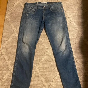 Replay anbass - Snygga blå jeans från Replay med en klassisk femficksdesign och lätt slitna detaljer. De är perfekta för en avslappnad stil. Märkeslappen i läder på baksidan ger en extra touch. Nypris ~ 1600kr. Mitt pris: 350kr skick 8/10 använda men inga hål. 