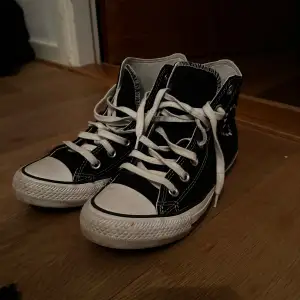 Snygga svarta Converse Chuck Taylor All Star med vita snören och detaljer. Skorna har ett hjärtmönster och texten 'love' broderad på sidan.
