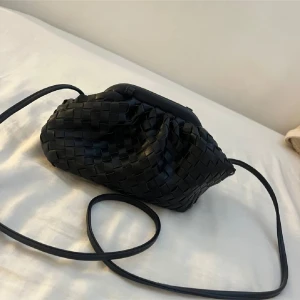 Svart flätad axelväska - Snygg svart axelväska med flätat mönster. Köpt här på plock men använd kanske 3 gånger 🥰 man knyter banden själv!!! 