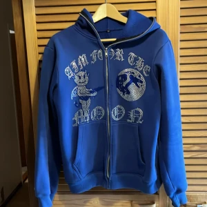 Blå hoodie med strassdetaljer - Säljer nu min aim for the moon hoodie, jag har använt den 1 gång då den inte passade mig riktigt. Den är överlag i super fint skick. Hör av er vid intresse och pris kan såklart diskuteras!