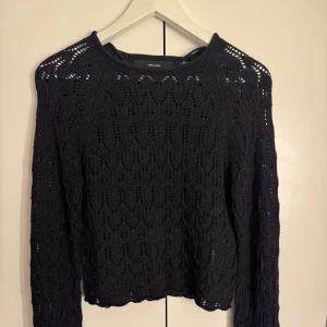 Svart stickad tröja - Säljer en svart stickad tröja med ett fint hålmönster. Tröjan har långa ärmar, köpte på vero moda, har använt endast en gång. 