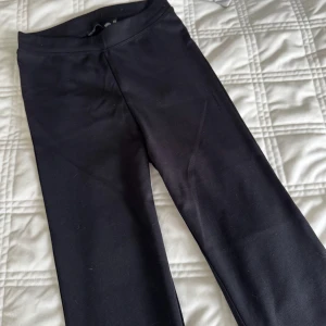 Svarta utsvängda byxor  - Snygga svarta utsvängda byxor i ett mjukt och stretchigt material. Helt nya aldrig använda Perfekta för en bekväm och stilren look. De har en enkel design utan detaljer och passar till många olika outfits.