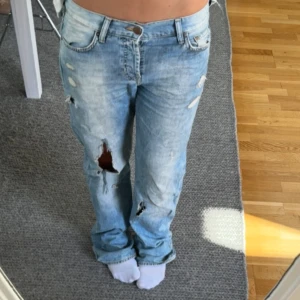 Snyggaste jeansen - Skitsnygga låga raka jeans med slitningar. Storlek 26 i modellen boyfriend💋💋Midjemått: 41 cm rakt över. Innerbenslängd: 81 cm