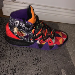 Kybrid s2 - Säljer ett par unika och färgglada sneakers med ett iögonfallande geometriskt mönster. Skorna har en kombination av lila, orange, röd och svart med snörning och en broderad logga på plösen. Perfekta för den som vill sticka ut!