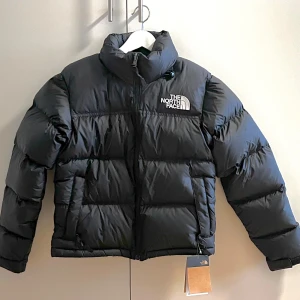 The North Face 1996 Retro Nuptse jacket - Säljer en helt ny svart TNF puffer-/dunjacka, dammodell 🙂