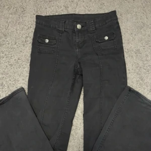 Slut sålda hm jeans - Snygga slutsålda H&M  jeans med unika fickdetaljer och knappar framtill. De har en rak passform och är perfekta för en stilren look. Midjan är normalhög och byxorna har en klassisk design med moderna inslag.
