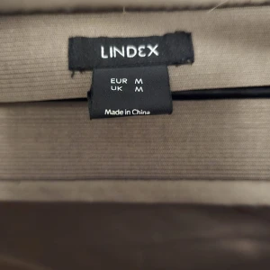 Beige långklänning från Lindex - Elegant beige långklänning från Lindex i ett mjukt och följsamt material. Perfekt för en stilren look med sin enkla design och långa längd. Klänningen har en vacker drapering som ger en smickrande silhuett.