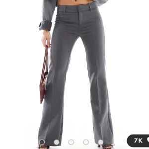 Grå kostymbyxor - Snygga grå kostymbyxor med låg midja och bootcut-stil. Tyvärr måste jag sälja dessa då dem var för små för mig! Dem har aldrig blivit använda och är i storlek 32 (OBS: Priset går att diskutera) 