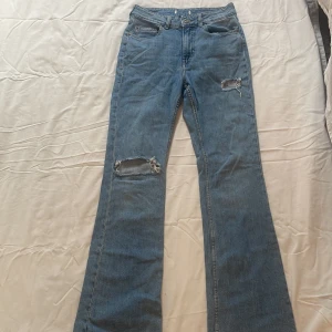 Blå jeans med slitningar - Snygga blå flared jeans med slitningar på låren. Byxorna är från H&M med lappen är bortklippt. Jeansen är i storlek 36 och är i bra skick💗💗💗