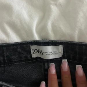 Svarta jeansbyxor från Zara - Snygga svarta jeansbyxor från Zara med fransiga kanter och slits vid anklarna. I storlek 24