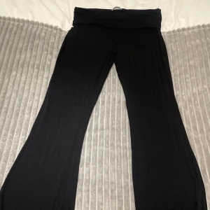 Svarta yoga pants - Jag säljer byxa med flare. Midja med kant att vika ner, väldigt mjukt och skönt material. Storlek L från lager 157