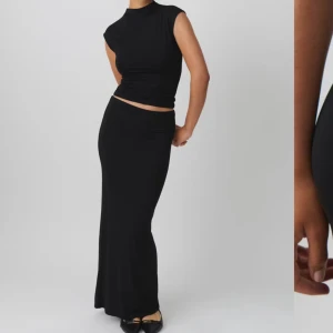 Svart långkjol - Elegant svart långkjol med en tight passform. Kjolen har en stilren design och är perfekt för vardag och fest. Den är i mjukt och följsamt material som framhäver siluett.