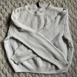 Vit stickad tröja från H&M - Säljer en stilren vit stickad tröja från H&M. Tröjan har en klassisk rund hals och långa ärmar med ribbade muddar. Enkel att matcha med olika outfits. Hör av dig vid intresse!