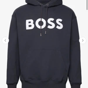 Svart hoodie från BOSS - Snygg mörkblå hoodie från BOSS med stor vit logotyp på bröstet. Den är endast testad så i nyskick , inga defekter eller annat!  Är du intresserad och vill se fler bilder skickar jag självklart egna bilder på alla delar 