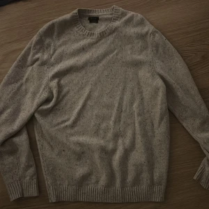Beige tröja från Massimo Dutti - Säljer en stilren beige tröja från Massimo Dutti. Tröjan är tillverkad i ett mjukt material och har en klassisk rund halsringning. Perfekt för kyligare dagar.