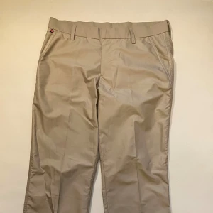 Beige chinos från J.Lindeberg - Snygga beige chinos från J.Lindeberg med klassisk design. Byxorna har en normal passform. Perfekta för en stilren look. W33 L34