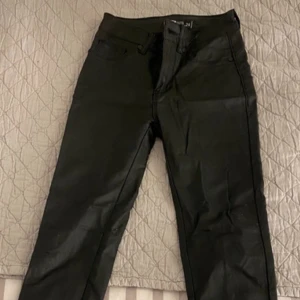 Svarta skinnbyxor - Snygga svarta byxor med en klassisk design. De har en rak passform och är tillverkade i ett slitstarkt material. Perfekta för en stilren look.