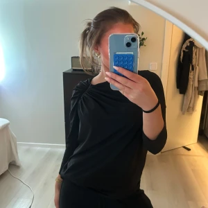 Svart långärmad topp med drapering - Snygg blus med en liten dragkedja vid axeln som gör blusen otroligt snygg!!🤩 